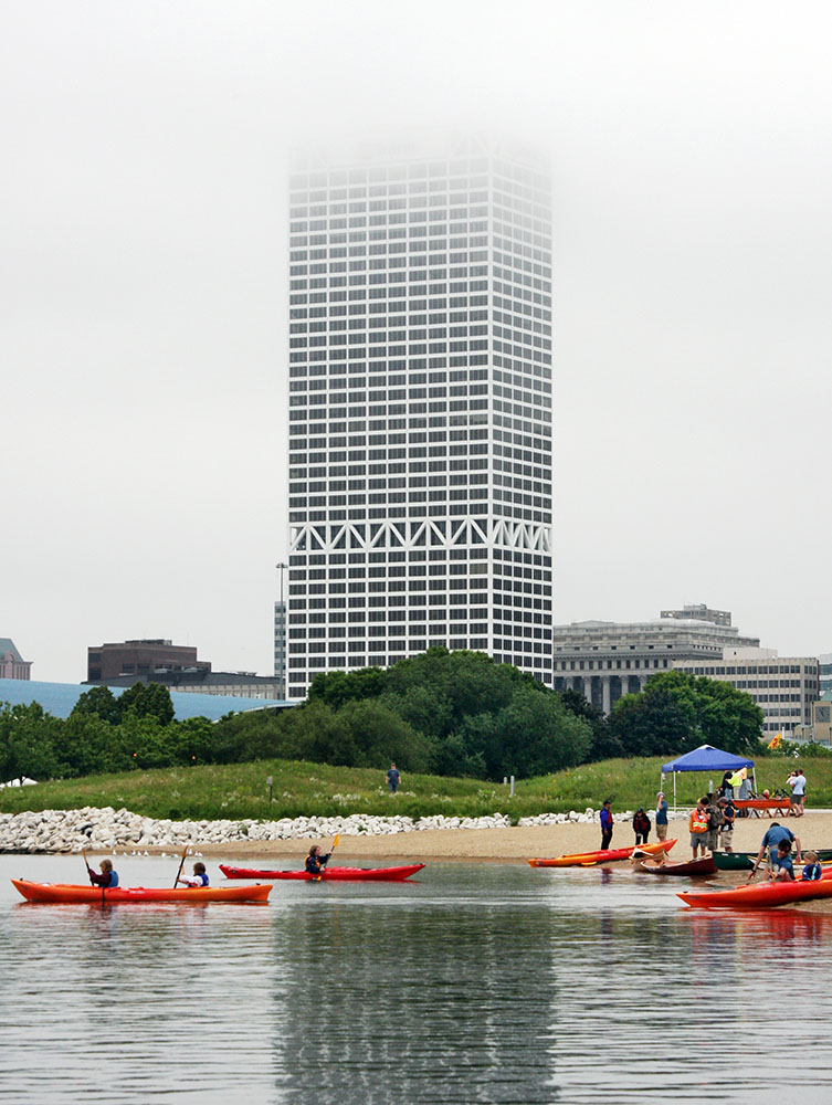 Fog that makes the US Bank tower seem to disappear forms the background for a kayaking event.