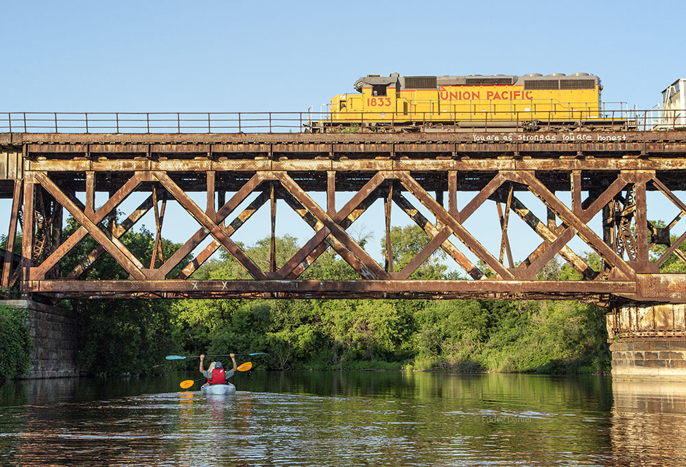 This image requires you to imagine the roar of the engine crossing the trestle and the whoops of the kayakers, then the whistle as the train engineer responds.