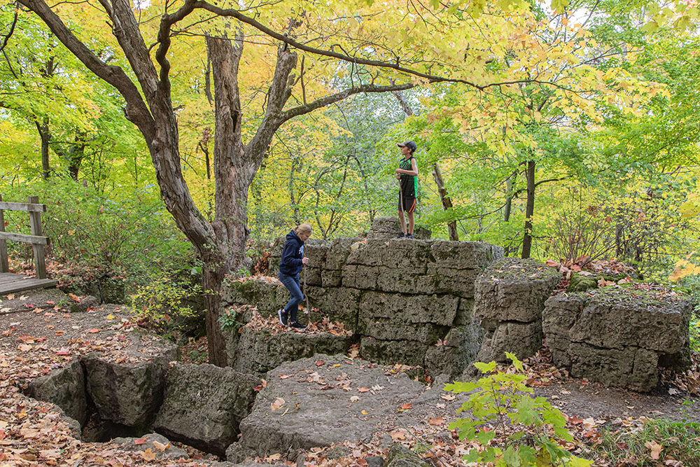 Mother and son climbing on the rocks at the edge of the ledge.