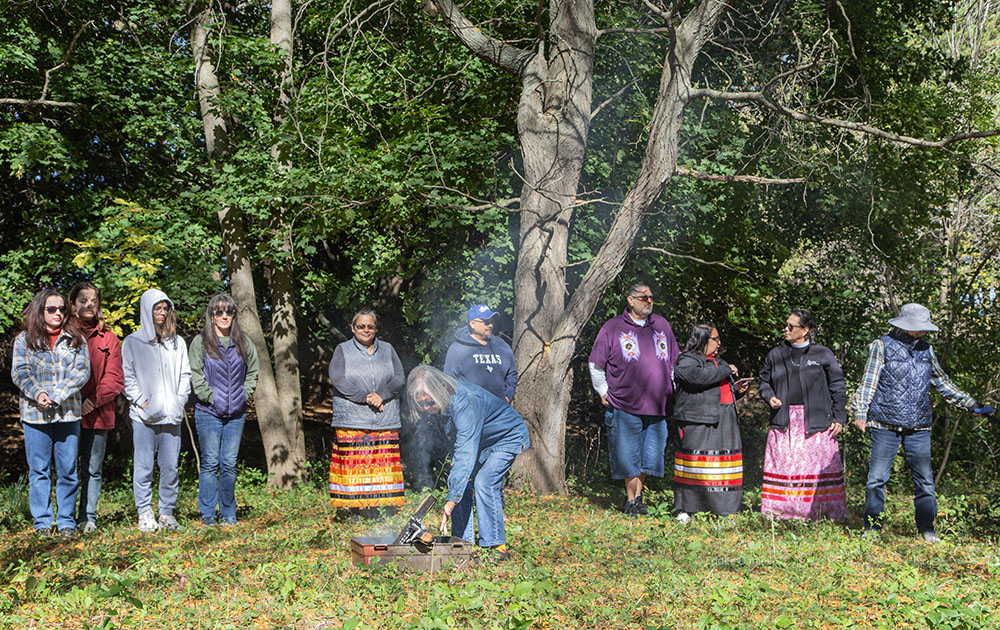 Placing the offering of tobacco on the sacred fire.