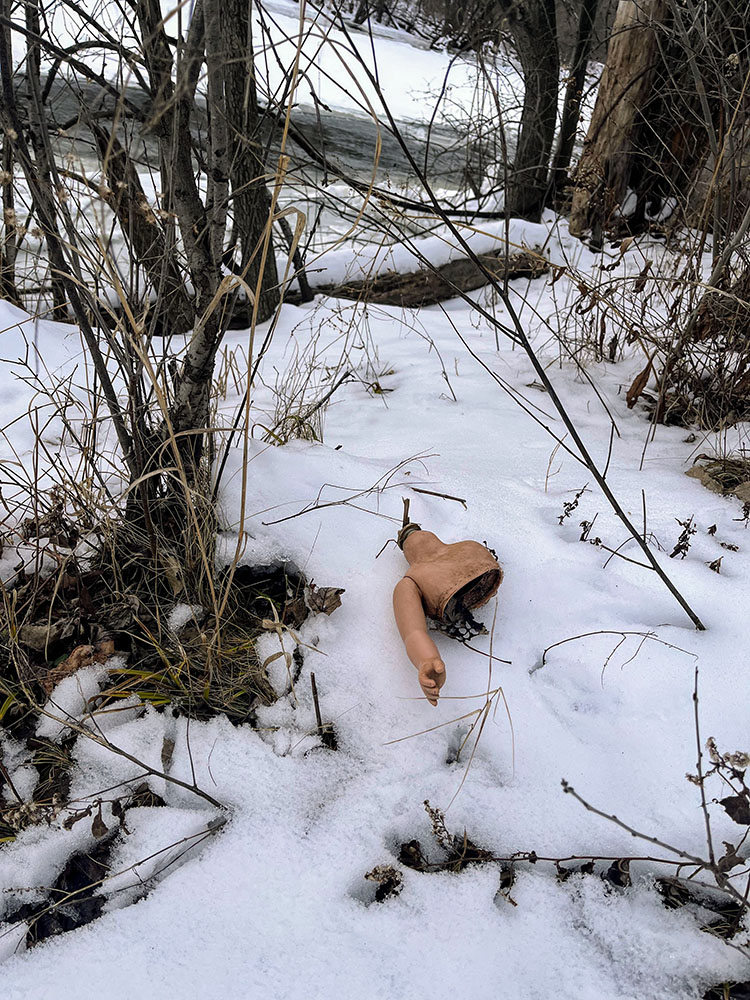 A broken doll in the snow along the Milwaukee River.