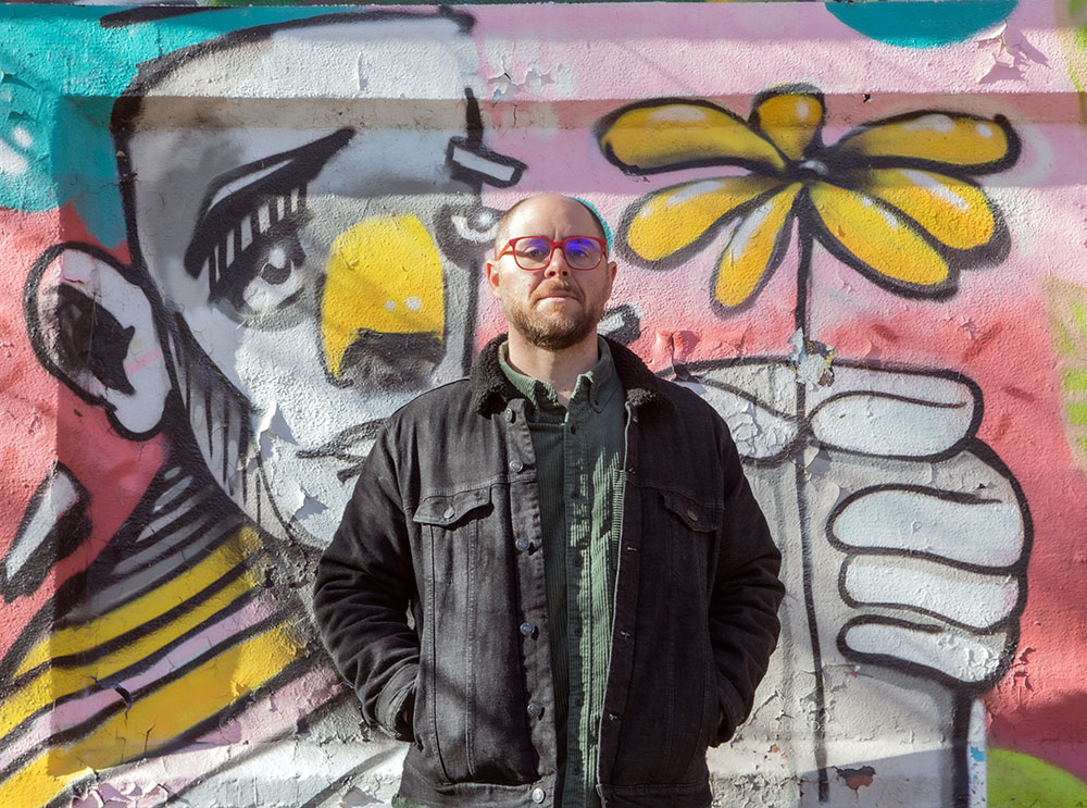 Brian Hibbard and grafitti in the Greenway. Photo by Eddee Daniel.