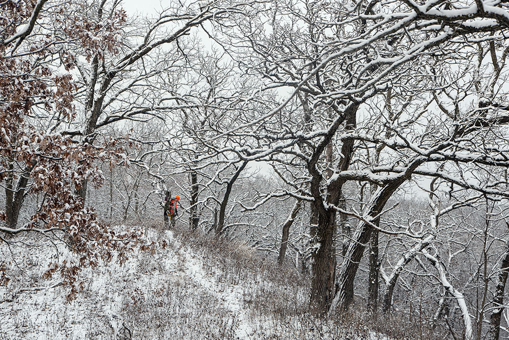 A hunter disappears over the edge of the ridge.