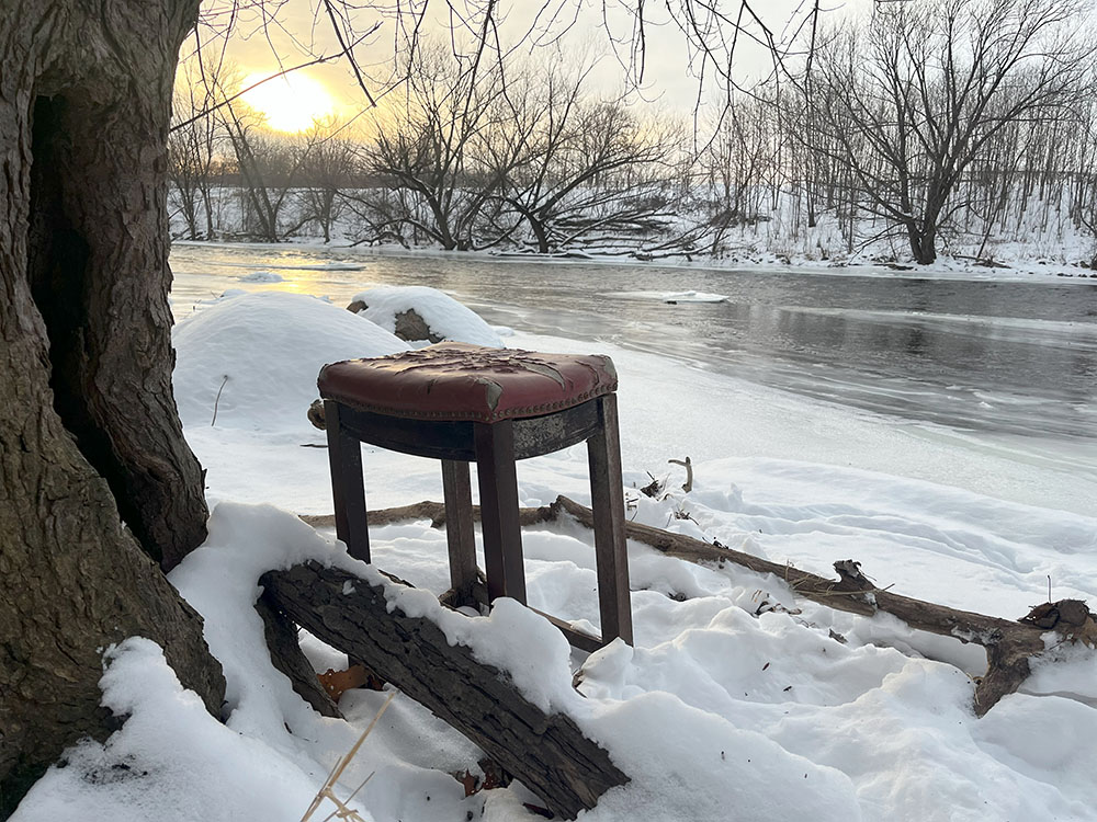 The sun sets on an old stool by the river.