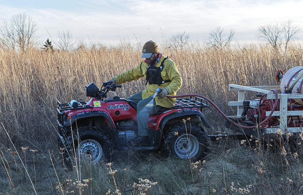 Ryan Wallin uses a heavy duty water sprayer to help separate one burn unit from another.