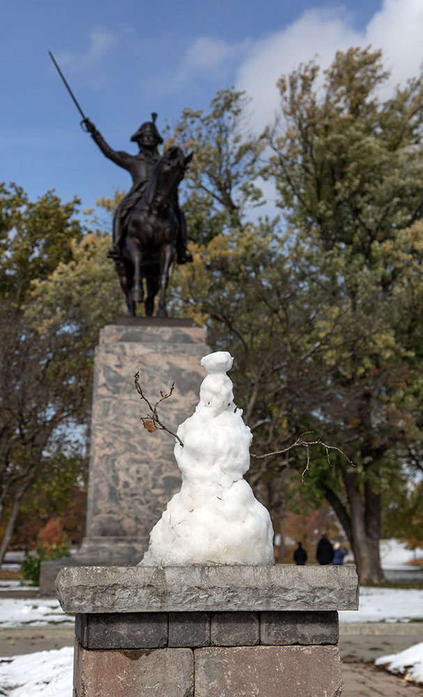 A whimsical snowman someone created on the plinth in front of the statue of Tadeusz Kosciuszcko after whom the park is named.