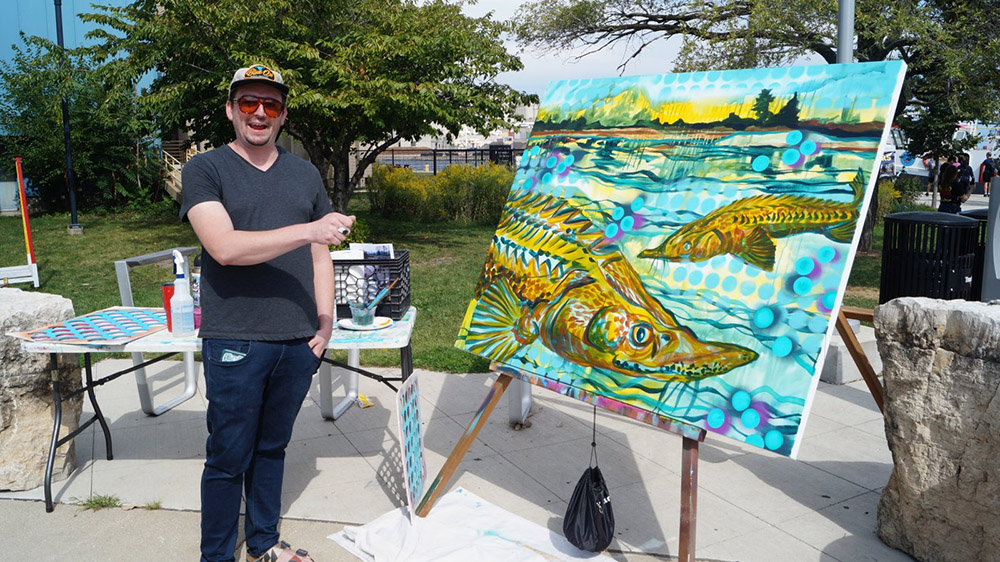 Milwaukee artist John Kowalczyk with his painting of sturgeon at Harbor Fest / Sturgeon Fest 2023.