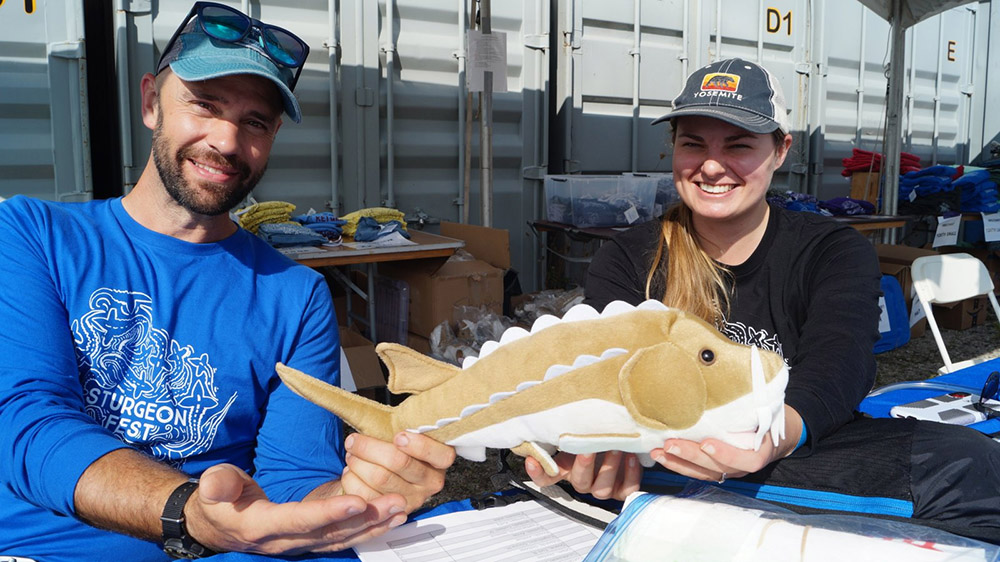 Riveredge Nature Center staffers Matt Smith and Anna Jean Hallman hold a plush sturgeon at their booth at Harbor Fest / Sturgeon Fest 2023.