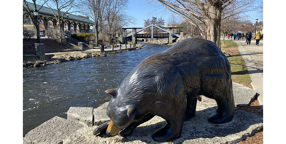 Brown bear sculpture next to the Fox River and Fox River Trail in Waukesha