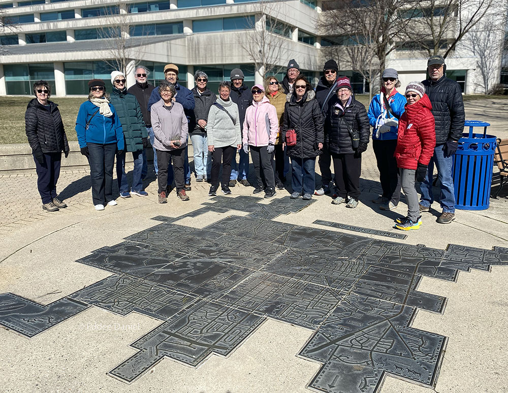 The Go-Hikers pause for a group portrait with the map of Waukesha at Barstow Plaza.