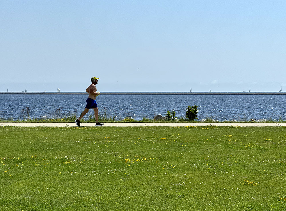 A jogger enjoys the wide-open spaces of the park and the Lake Michigan horizon.