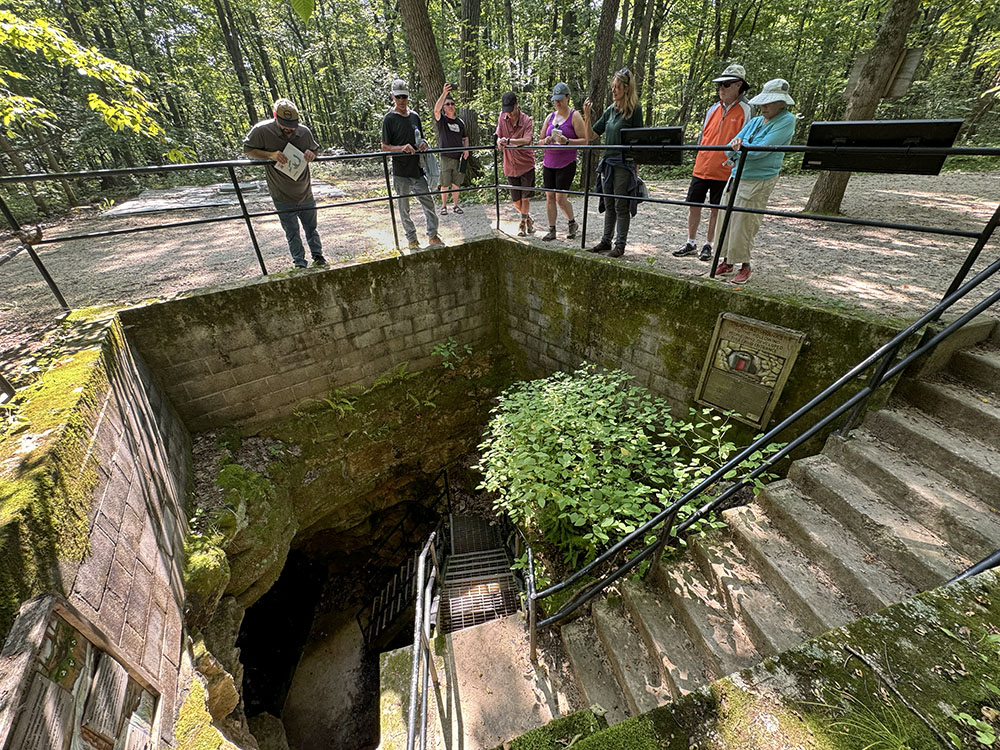 The main cave entrance descends into a naturally occurring sink hole.