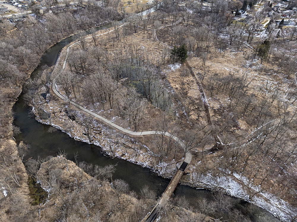 The Root River Pathway crosses and then runs alongside the Root River in Colonial Park.