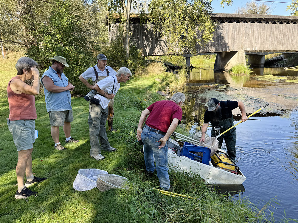 Visitors gather around the beached boat to view the catch.