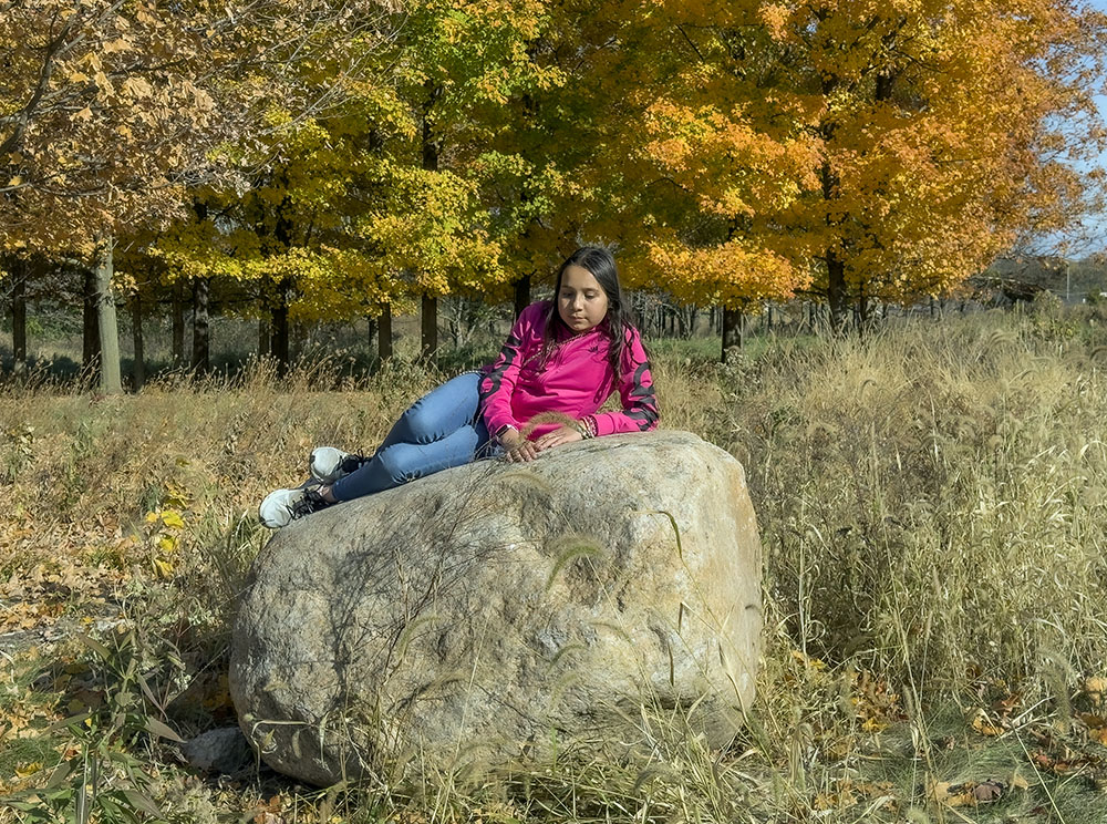 Seeing a convenient boulder, Lynn takes a short break, perhaps channeling the Little Mermaid, whom she plans to be for Halloween.