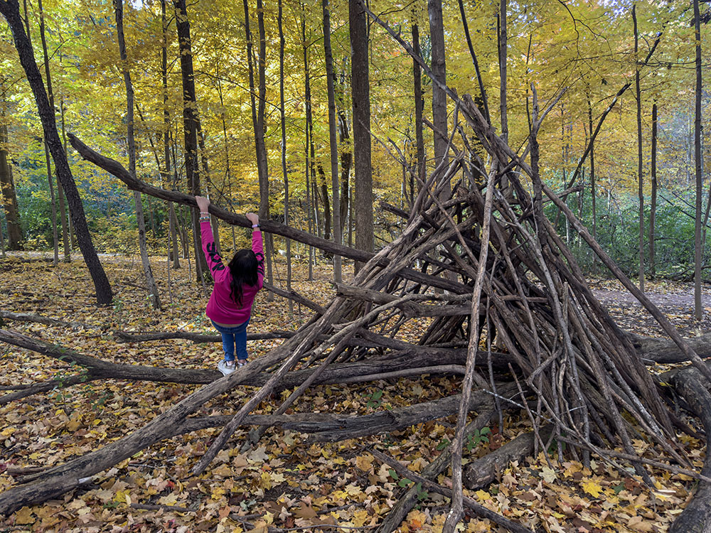 A stick fort doubles as a jungle gym.