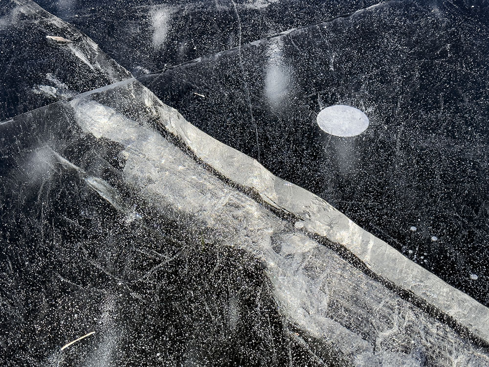 Cracks (and bubbles) in clear ice can reveal how thick the ice is. This ice on the lagoon at Greenfield Park in West Allis was at least four inches thick. The sound of the ice cracking can be unnerving, but when it's this thick it remains stable.