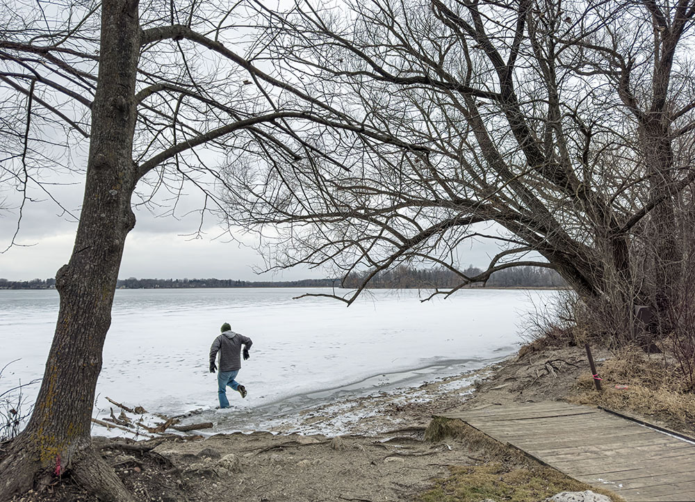 This man thought he was jumping over open water onto solid ice. I caught him as he broke through the thinner ice at the edge. Luckily for him the water was not deep right there. Kettle Moraine State Forest - Pike Lake Unit.