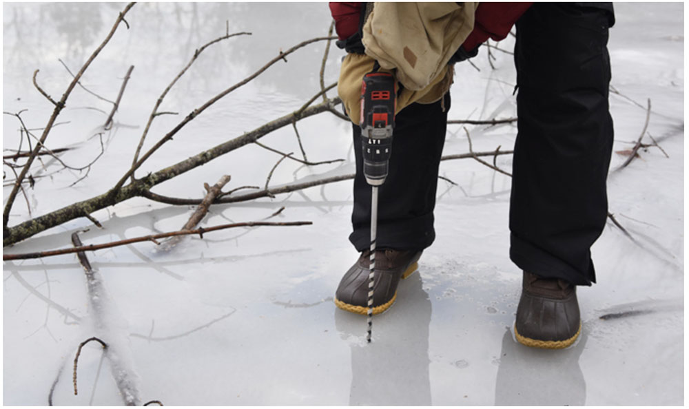 Using a drill to determine the thickness of the ice. Photo courtesy Schlitz Audubon Nature Center.