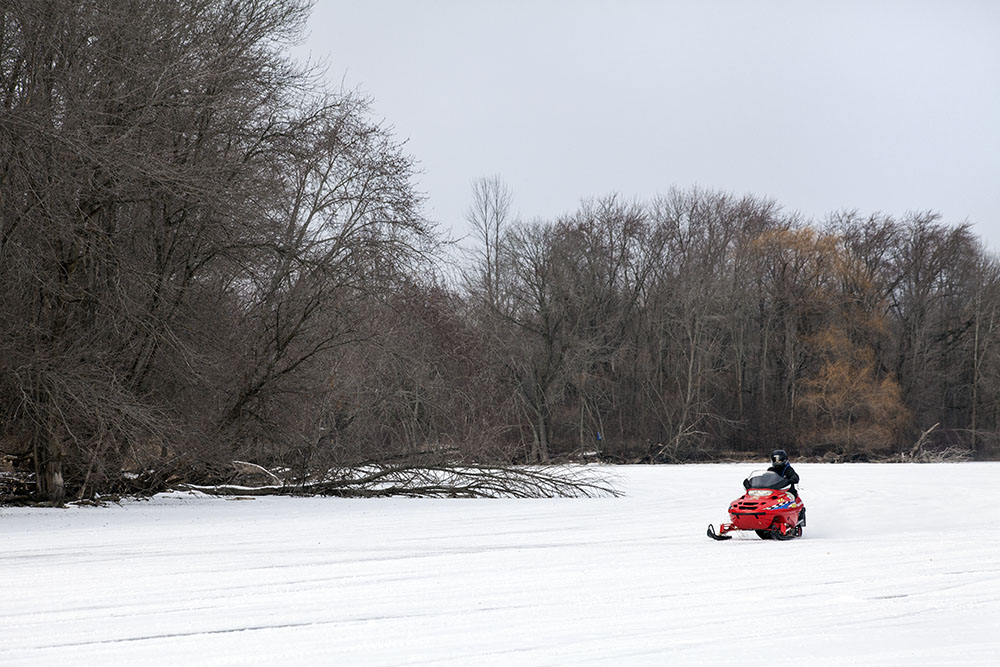 A snowmobile on the ice of the Milwaukee River at Shoreland Nature Preserve in Mequon.