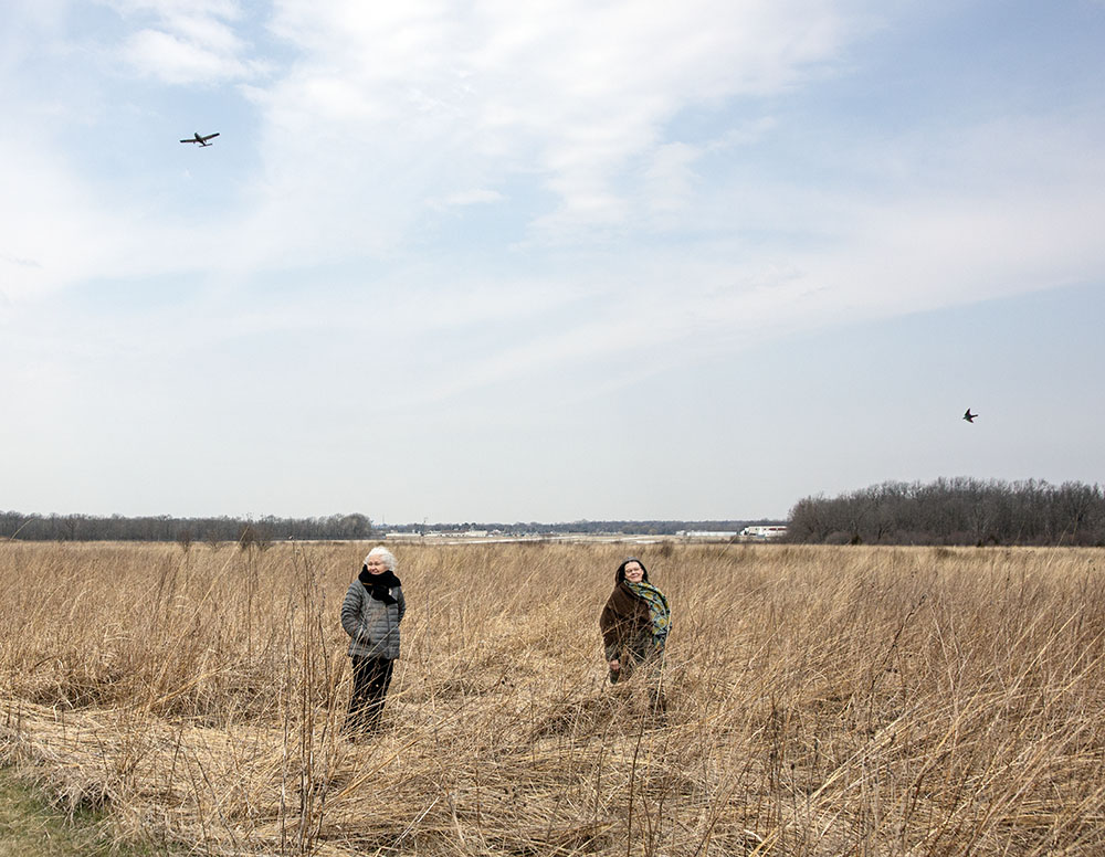 A plane takes off from the West Bend Airport (background) as a swift swoops over the heads of the two artists.