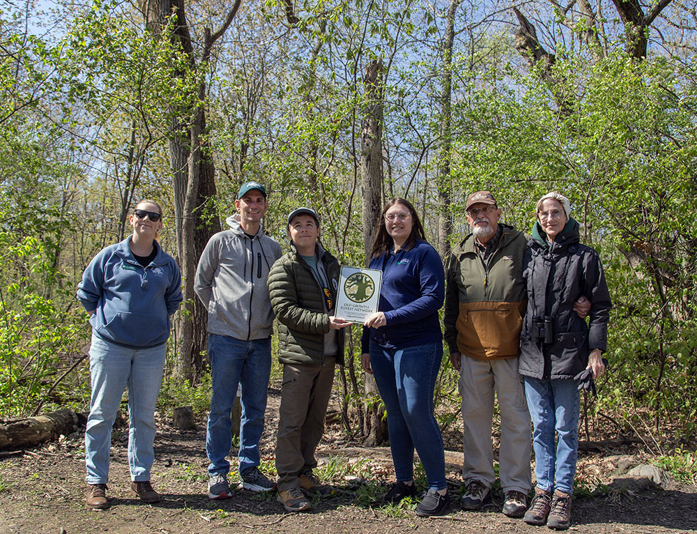 Officials from Pringle Nature Center and Kenosha County Parks receiving the award plaque from the Old-Growth Forest Network.