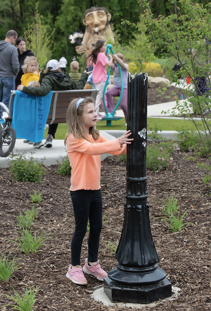 A girl discovers one of the broken lampposts.