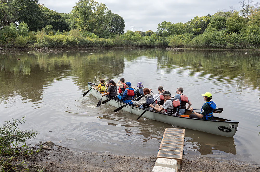 The canoe takes off from the boat launch.