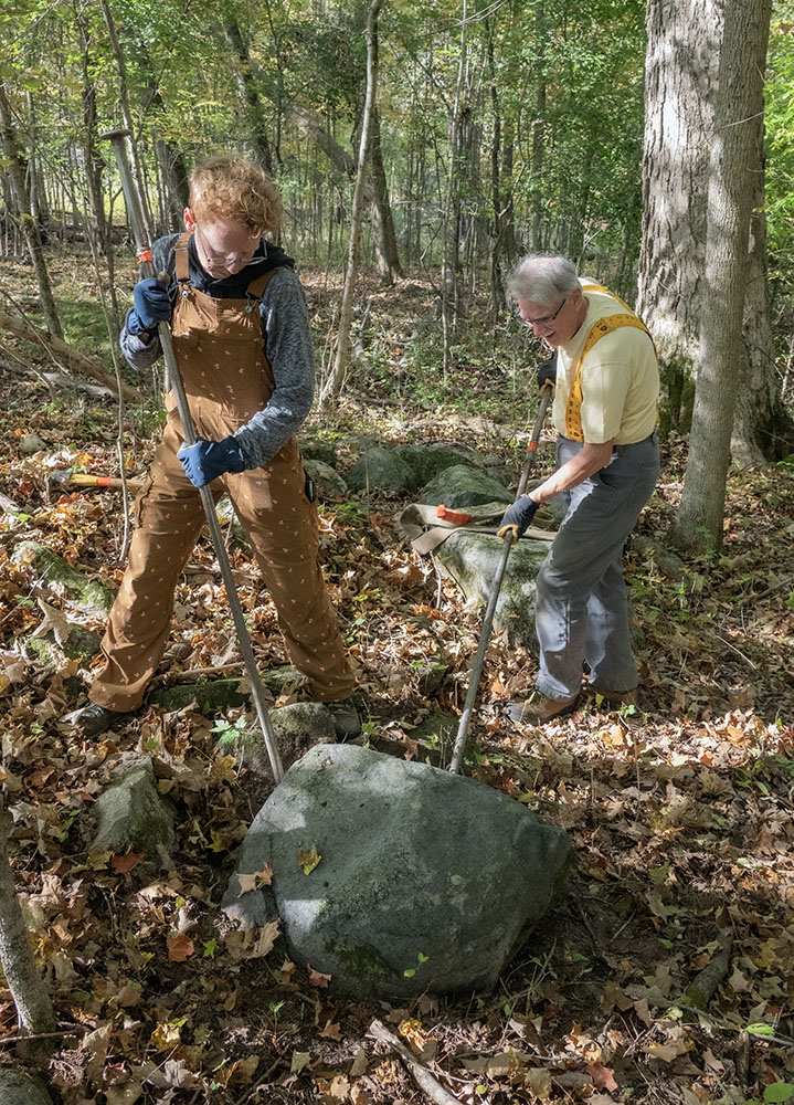 A large rock being quarried in the woodland nearby.