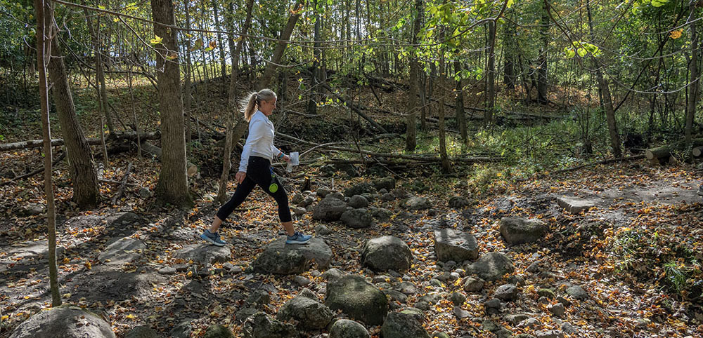 Hiker crossing stepping stones on Ice Age Trail