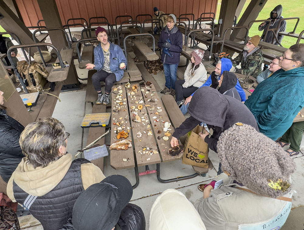 Out of the rain, in a picnic shelter, the group lays its treasures out on a table for "show and tell."