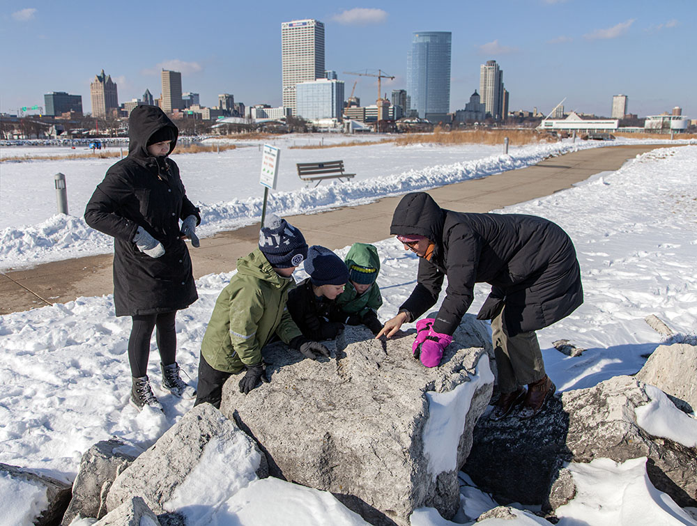 Children examining fossils on a guided winter hike through the park.