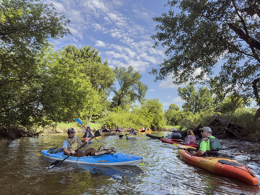 The participants drift patiently while a logjam is being cleared up ahead.
