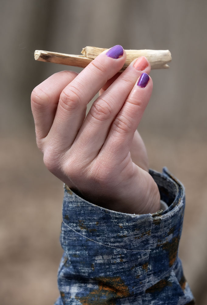A tour guide holds a sample wooden spile similar to ones that might have been used by the indigenous people who first learned how to turn sap into syrup.