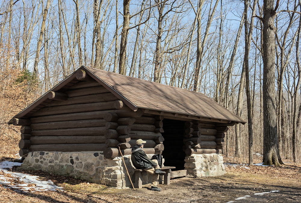 A backpacking shelter offers a rest stop; warmer outside in the bright sun!
