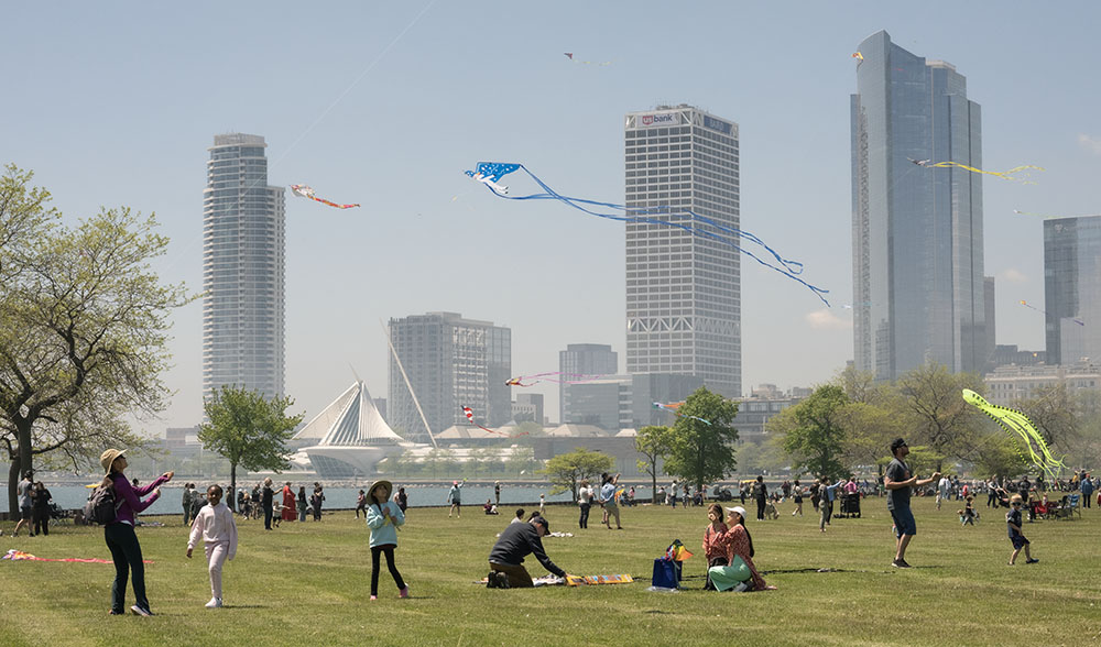 People flying kites with the Milwaukee skyline in the background