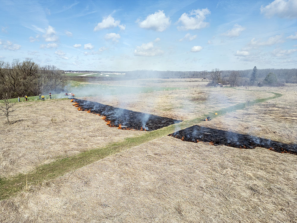 The burn just getting underway. Restoring Lands makes an effort to be a good neighbor to West Bend Airport, which is visible in the background. 