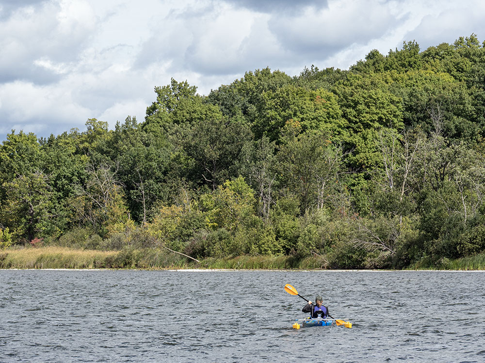 A visitor tries out an adaptive kayak with pontoons for stability.