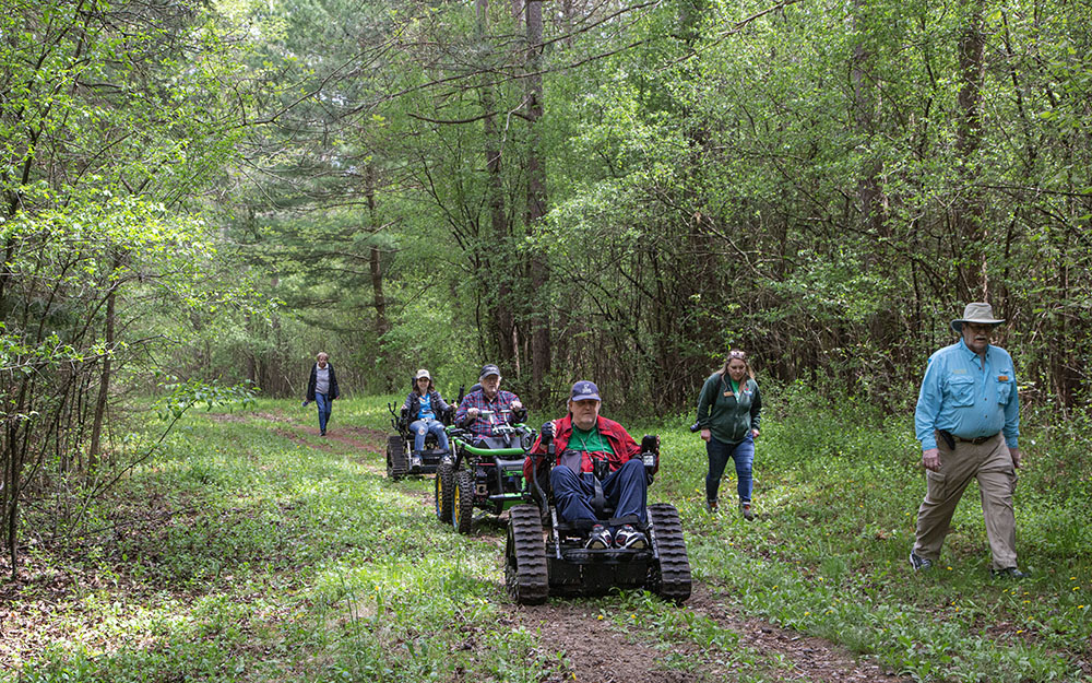 A duo of all-terrain wheelchairs and an adaptive ATV head out on the Scuppernong Trails during Outwigo Green at the Southern Unit of the Kettle Moraine State Forest.