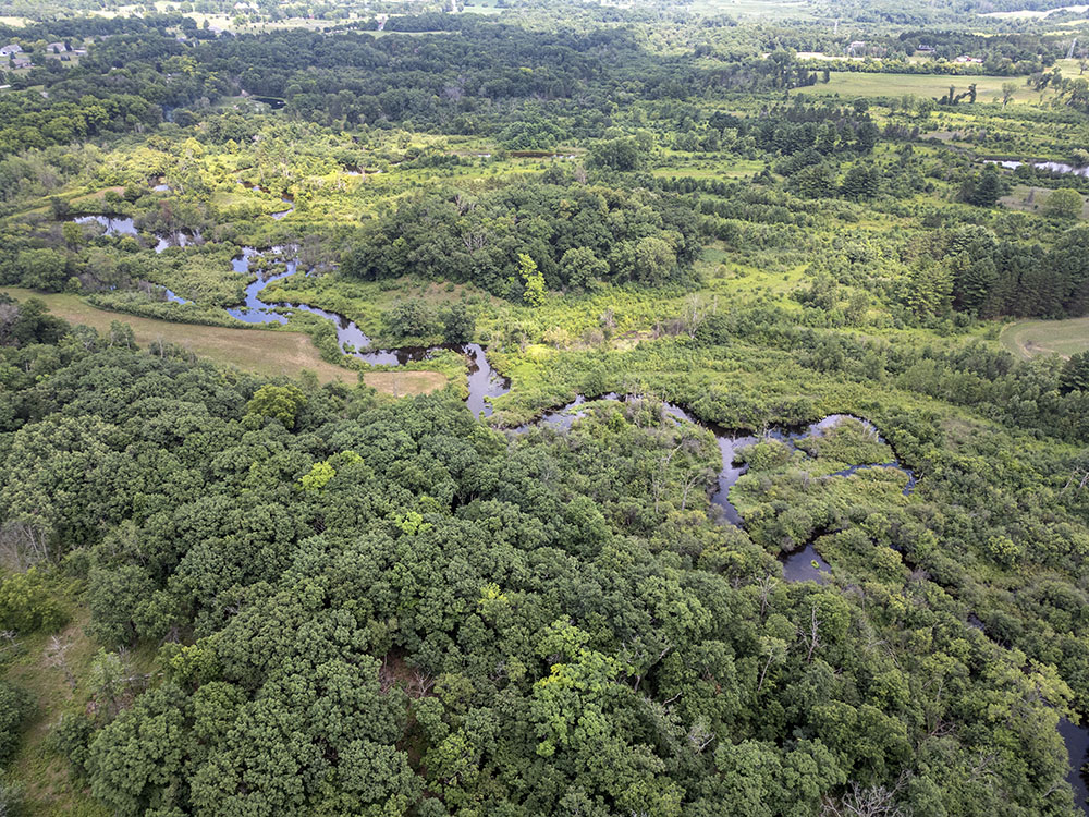 The meandering Mukwonago River roughly divides the Waukesha County preserve (lower left) and the Kettle Moraine State Forest (upper right).