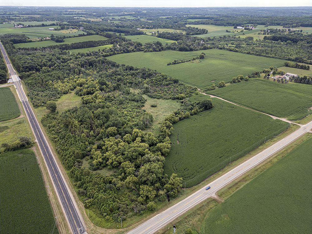 The Joerres property sits at the intersection of Highways A and M in Washington County, on the Milwaukee River. The cornfields to the right of the woodland await restoration to prairie.