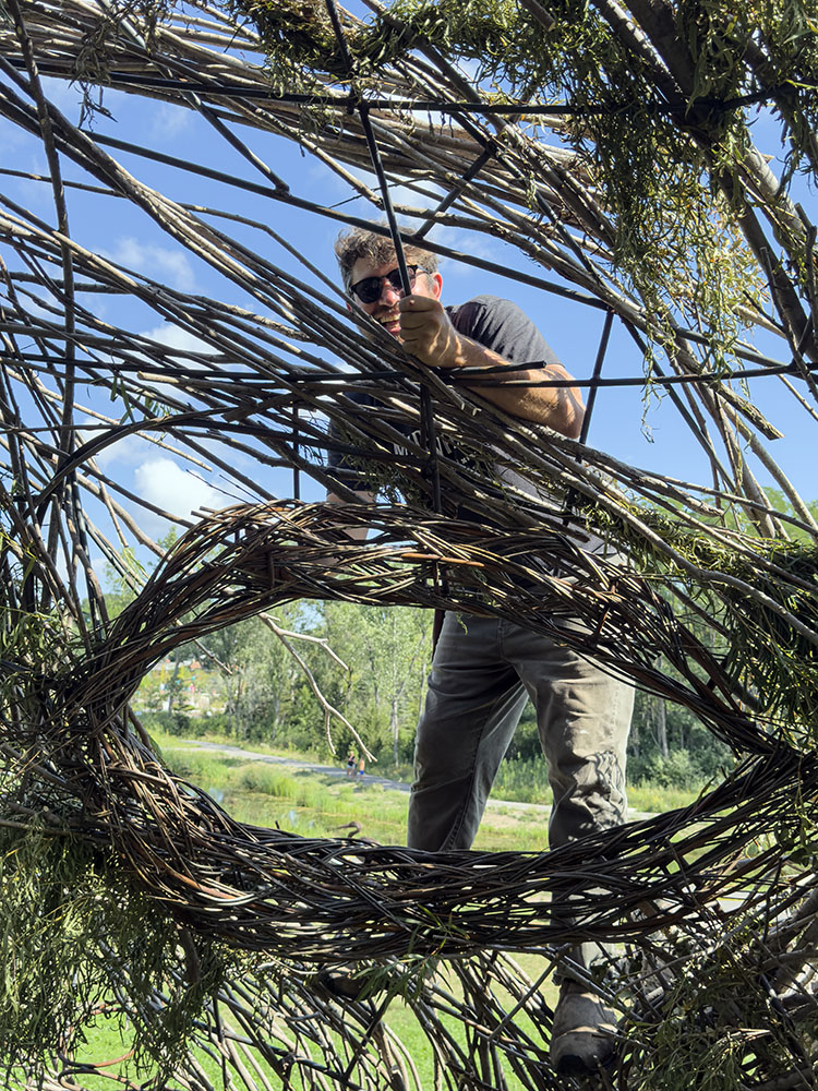 Justin Roberts adds a willow branch to the unfinished head, seen from the interior.