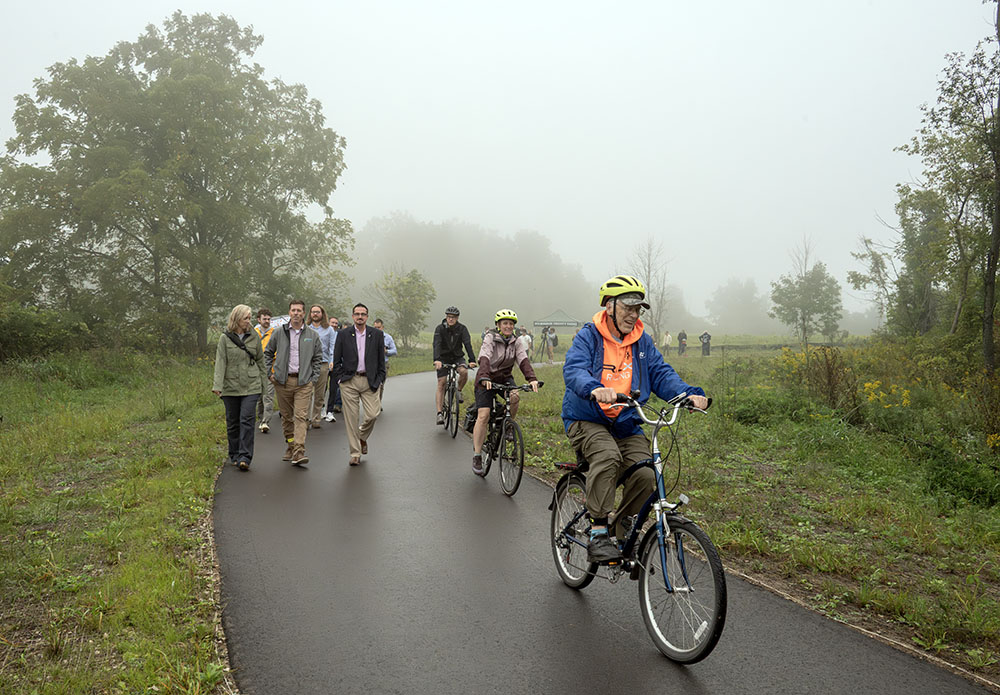A contingent of walkers follows along behind the cyclists. 