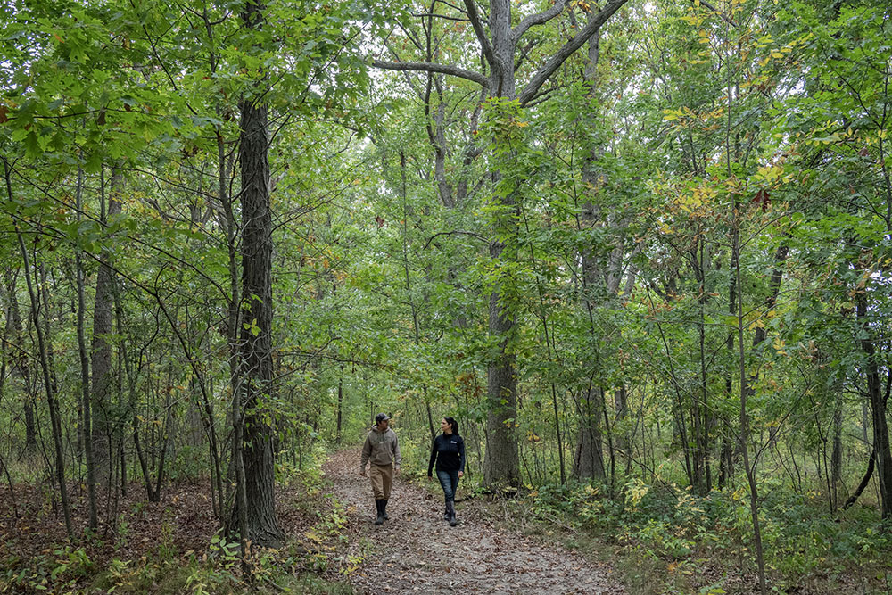 Anthony Hatcher of Pheasants Forever and Kristin Schulteis of MMSD walk a woodland trail in the Watson property in Oak Creek.