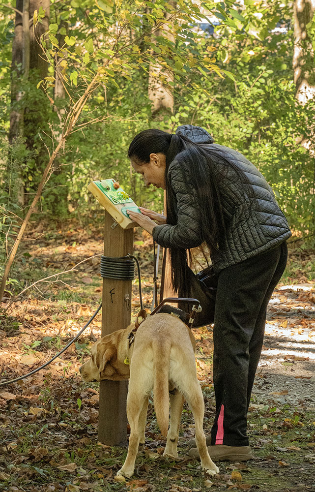 A blind visitor reads the braille inscription.